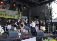 Grupka dzieci tańczy na scenie.